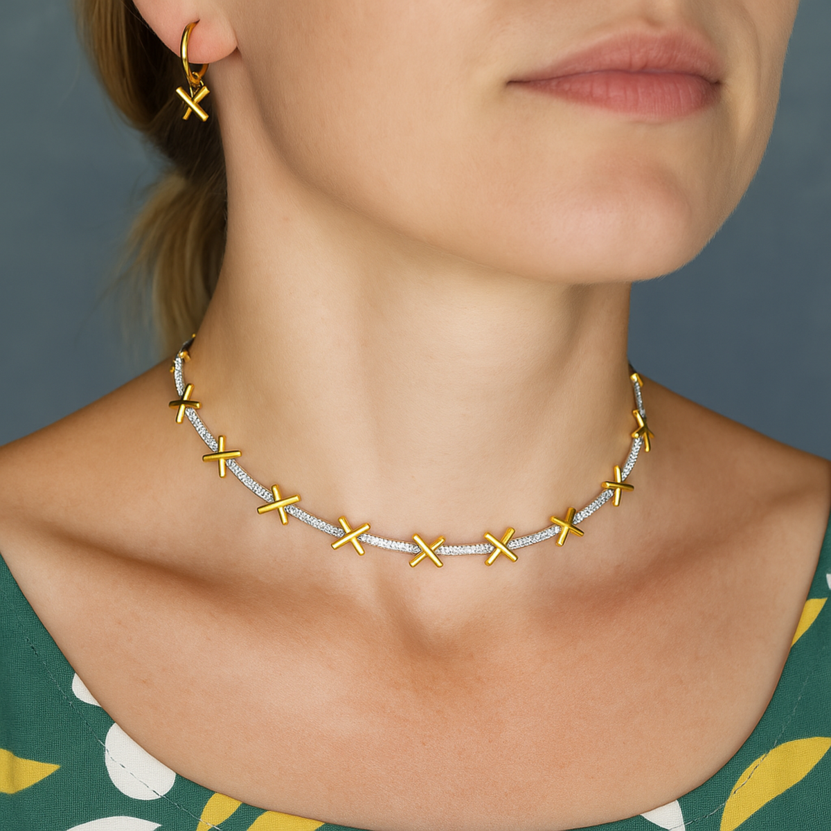 A delicate sterling silver necklace with gold plated kiss charms separated by sparkling CZ stones. Comes with small extension chain