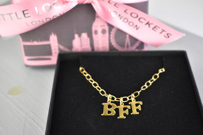 Model wears Necklace chain with and letters. Crafted with a 5.5mm link size chain in gold vermeil with serif letters spelling out  BFF (Best Friends Forever). Each letter is a classic serif uppercase font.