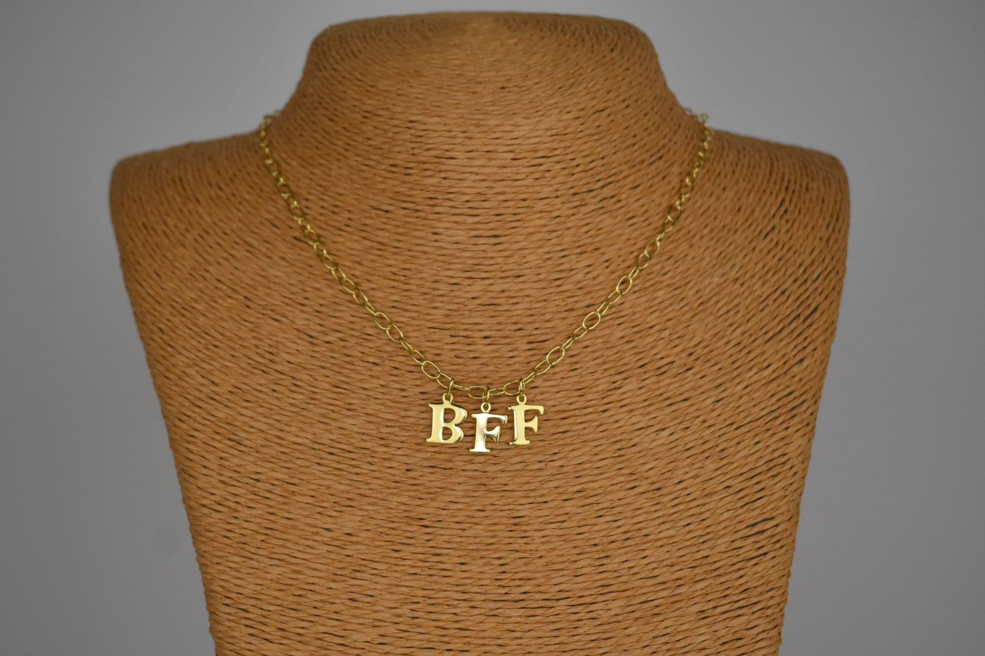 Model wears Necklace chain with and letters. Crafted with a 5.5mm link size chain in gold vermeil with serif letters spelling out  BFF (Best Friends Forever). Each letter is a classic serif uppercase font.