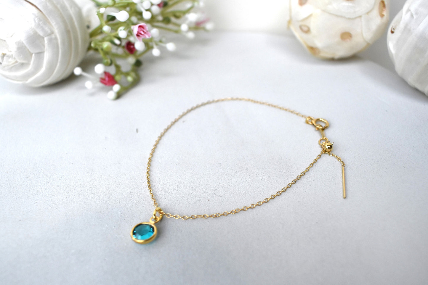 A gold filled chain is  threaded through a bead to make this delicate bracelet adjustable. Finished with a birthstone of your choice, ths bracelet is the perfect summer accessory.