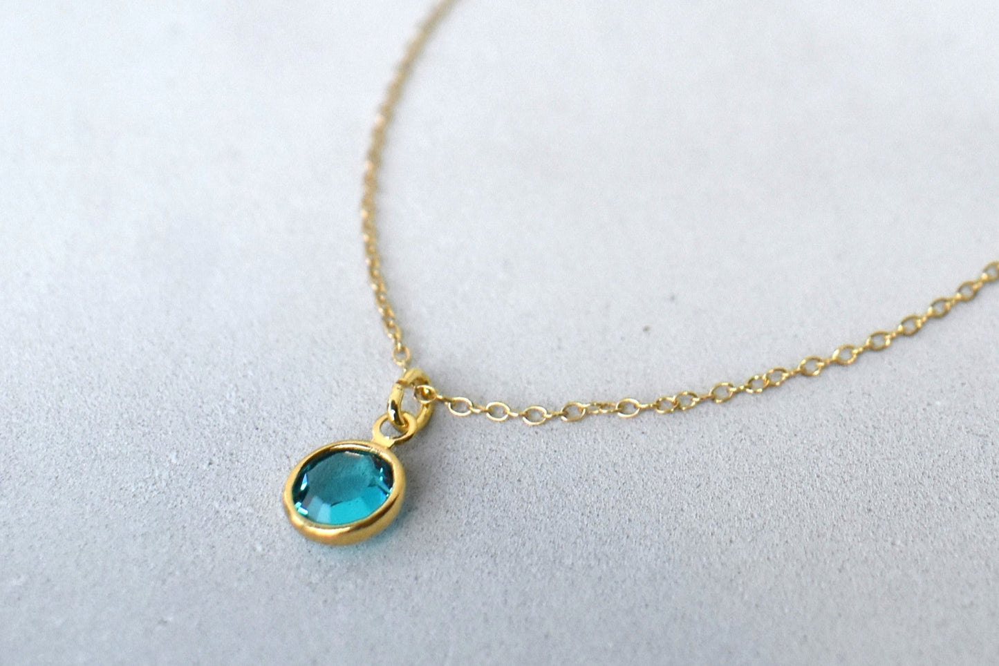 A gold filled chain is  threaded through a bead to make this delicate bracelet adjustable. Finished with a birthstone of your choice, ths bracelet is the perfect summer accessory.