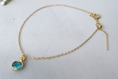 A gold filled chain is  threaded through a bead to make this delicate bracelet adjustable. Finished with a birthstone of your choice, ths bracelet is the perfect summer accessory.
