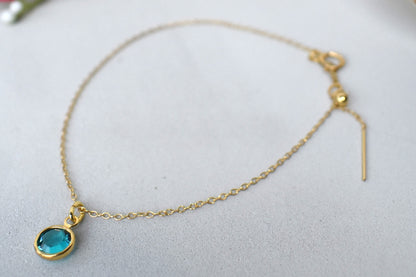 A gold filled chain is  threaded through a bead to make this delicate bracelet adjustable. Finished with a birthstone of your choice, ths bracelet is the perfect summer accessory.