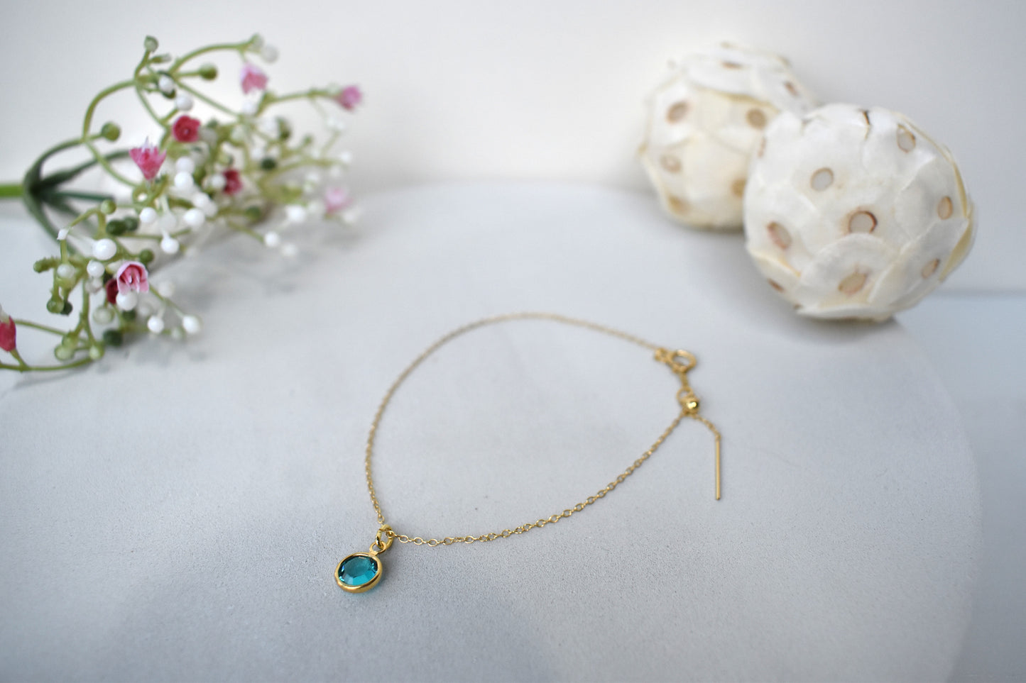 A gold filled chain is  threaded through a bead to make this delicate bracelet adjustable. Finished with a birthstone of your choice, ths bracelet is the perfect summer accessory.