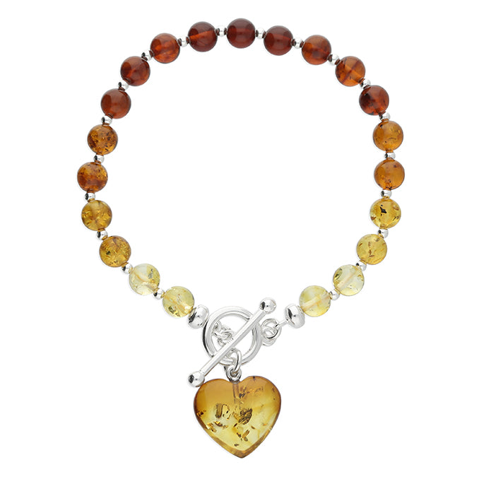 Cognac amber graduated bead bracelet  in varying and graduated tones of amber fastened with sterling silver TBar clasp and dangling heart charm. 