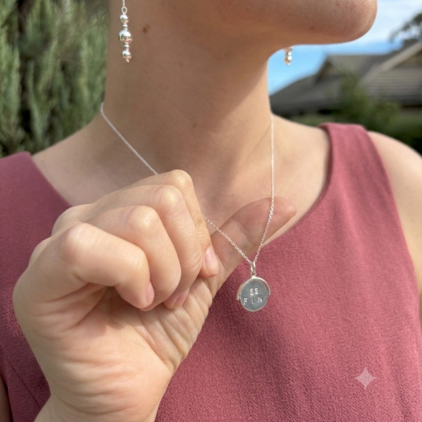 The sterling silver disc pendant spins to show the message "best friend"