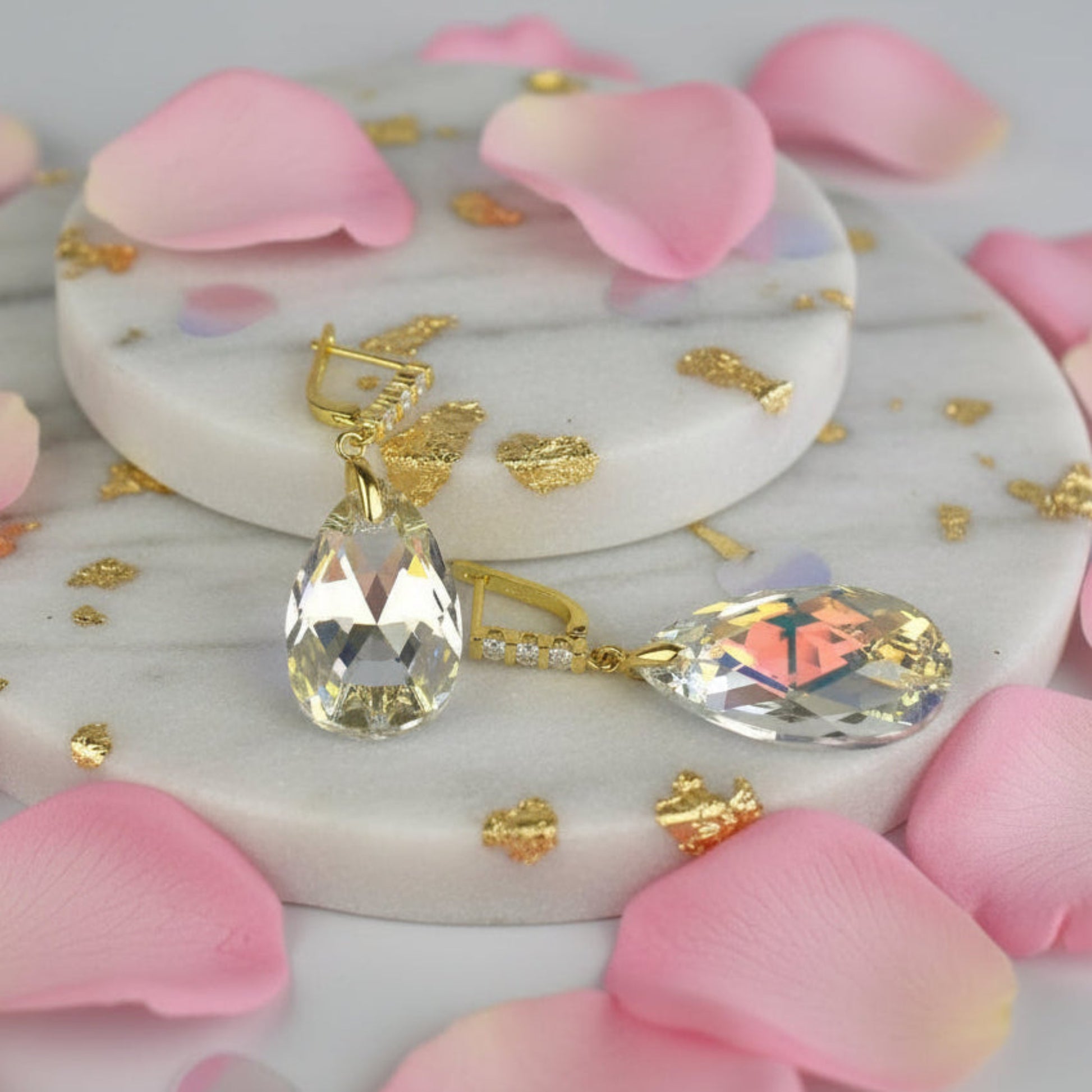 Beautiful Austrian crystal pear drops are suspended from gold plated sterling silver lever back earrings studded with three tiny zircona.