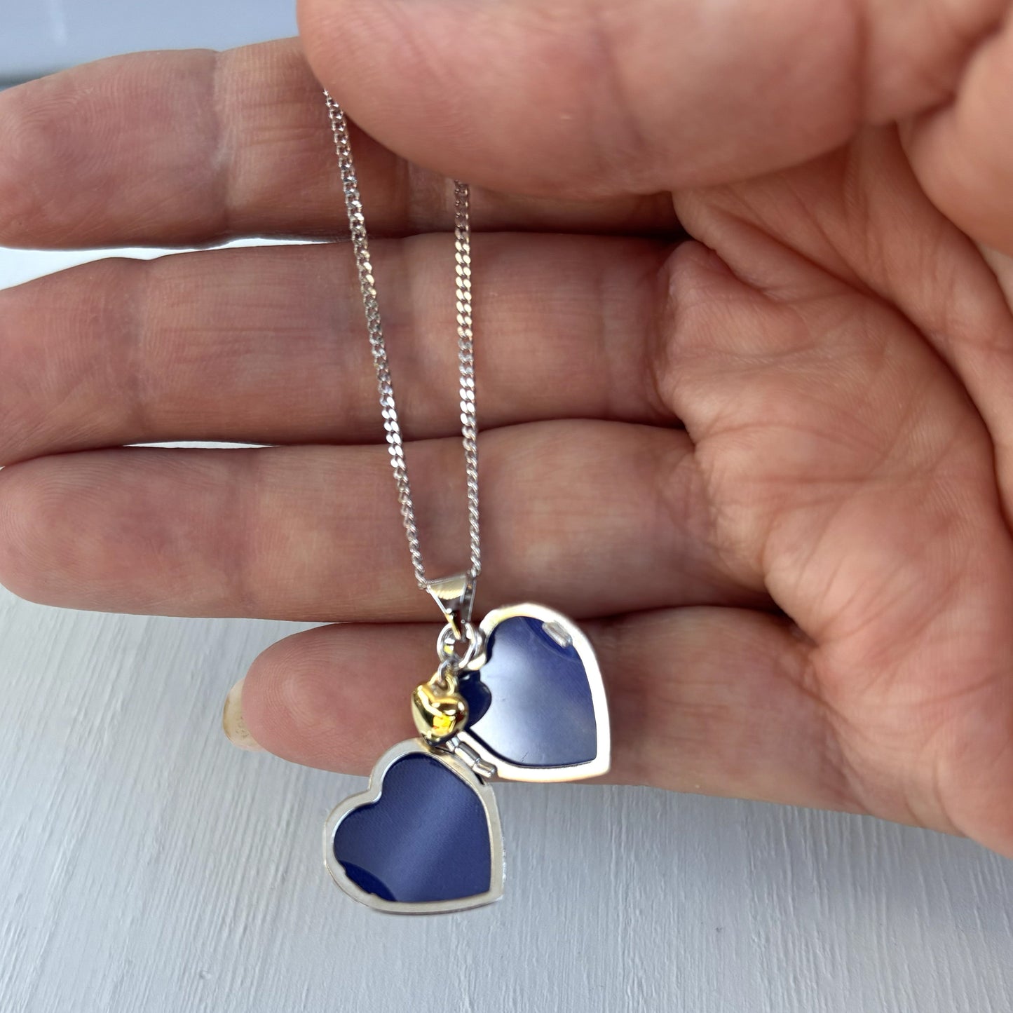Personalised Sterling Silver & Gold Plated Diamond Heart Locket Necklace features a small inset diamond shown open and in hand for sizing