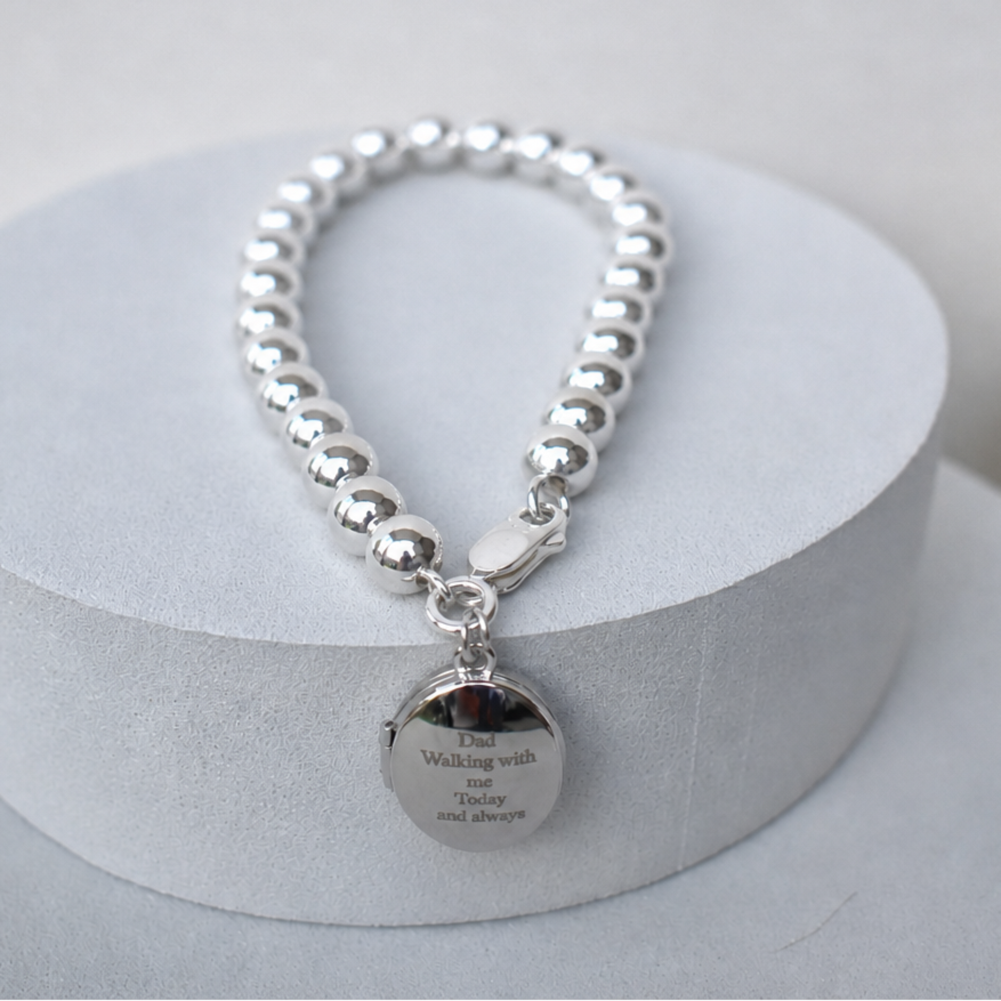 Sterling silver 6mm beaded bracelet with engraved locket at fastener. The engraving reads Dad, walking with me today and always