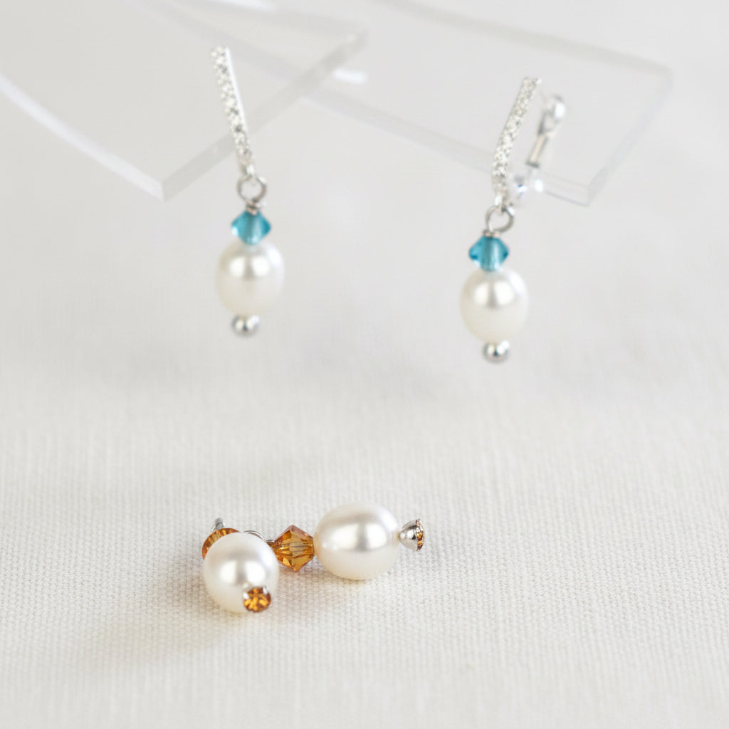 freshwater pearl earrings with amber  Austrian crystals hung from your choice of sterling silver or gold platedear wires trimmed with diamante