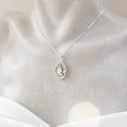 Sterling silver pear-shaped glass locket with tiny heart and key charms on a beaded chain