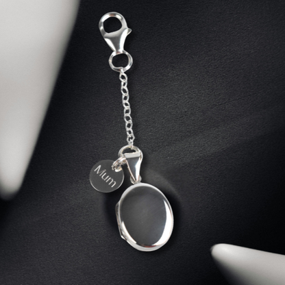 Sterling silver oval photo pocket locket shown with engraved round tag
