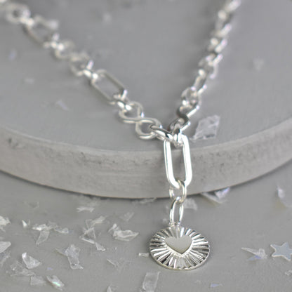 Sterling Silver Handmade Flat Link Infinity Necklace featuring a Heart Rays Pendant. Showcases flat oval and infinity links and features a Sterling Silver Sunburst Heart Rays charm pendant surrounded by an intricate sun rays design