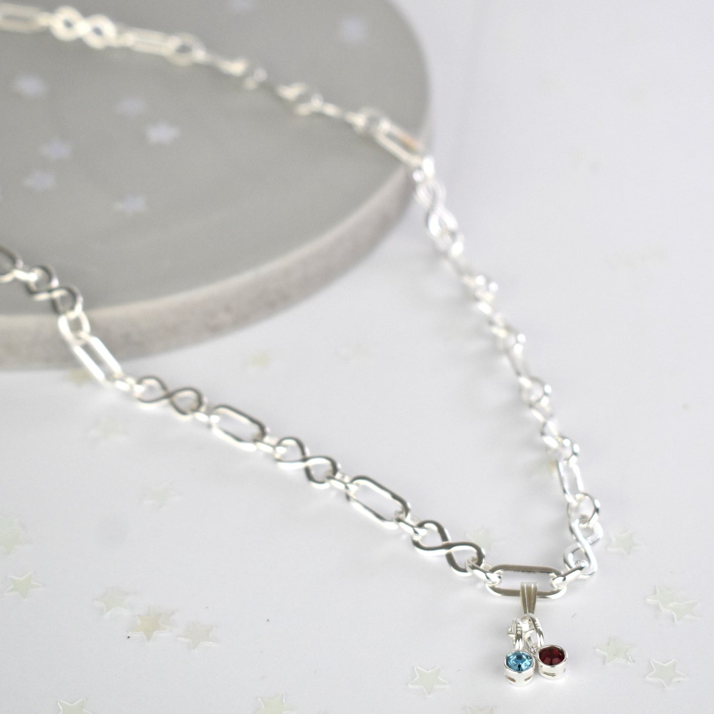 Sterling silver necklace of linked infinity symbols hung with birthstones of your choice