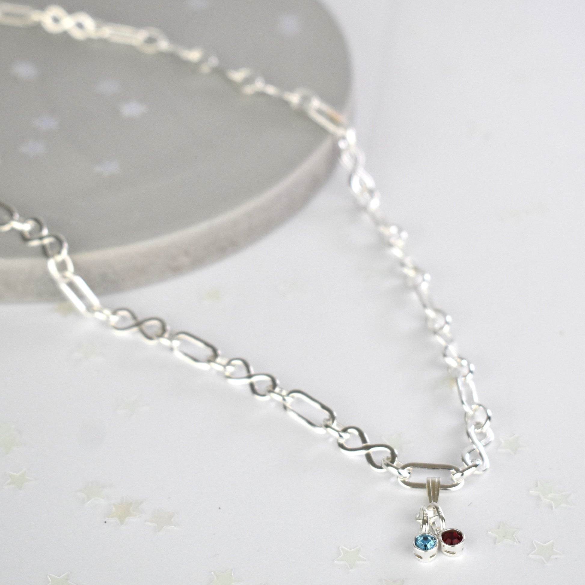 Sterling silver necklace of linked infinity symbols hung with birthstones of your choice