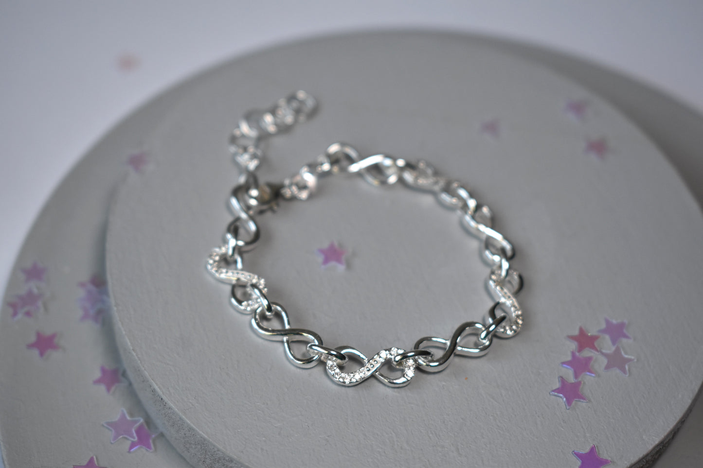 Sterling silver Infinity link bracelet with cubic zirconia inlays. Adjustable.