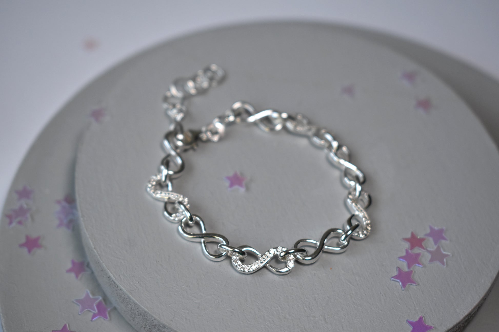 Sterling silver Infinity link bracelet with cubic zirconia inlays. Adjustable.