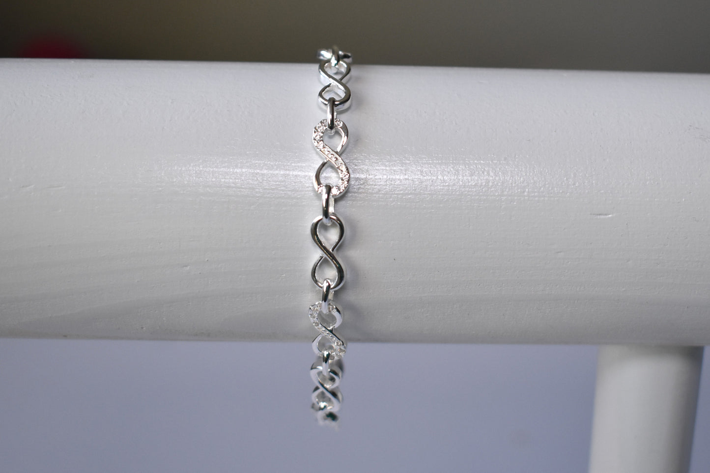 Sterling silver Infinity link bracelet with cubic zirconia inlays. Adjustable.