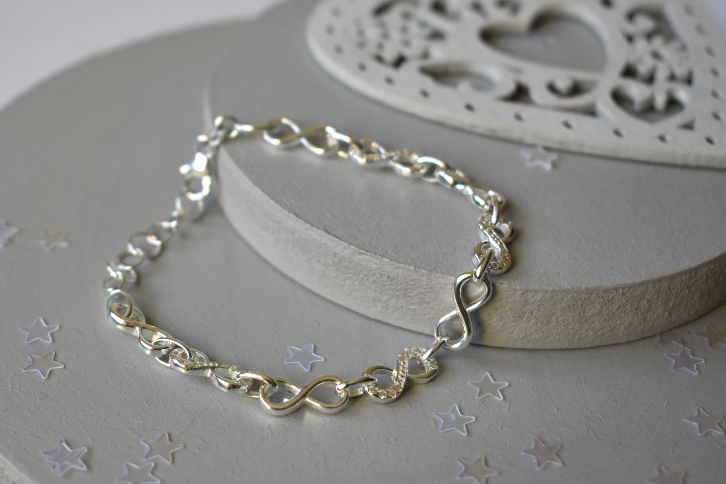 Sterling silver Infinity link bracelet with cubic zirconia inlays. Adjustable.