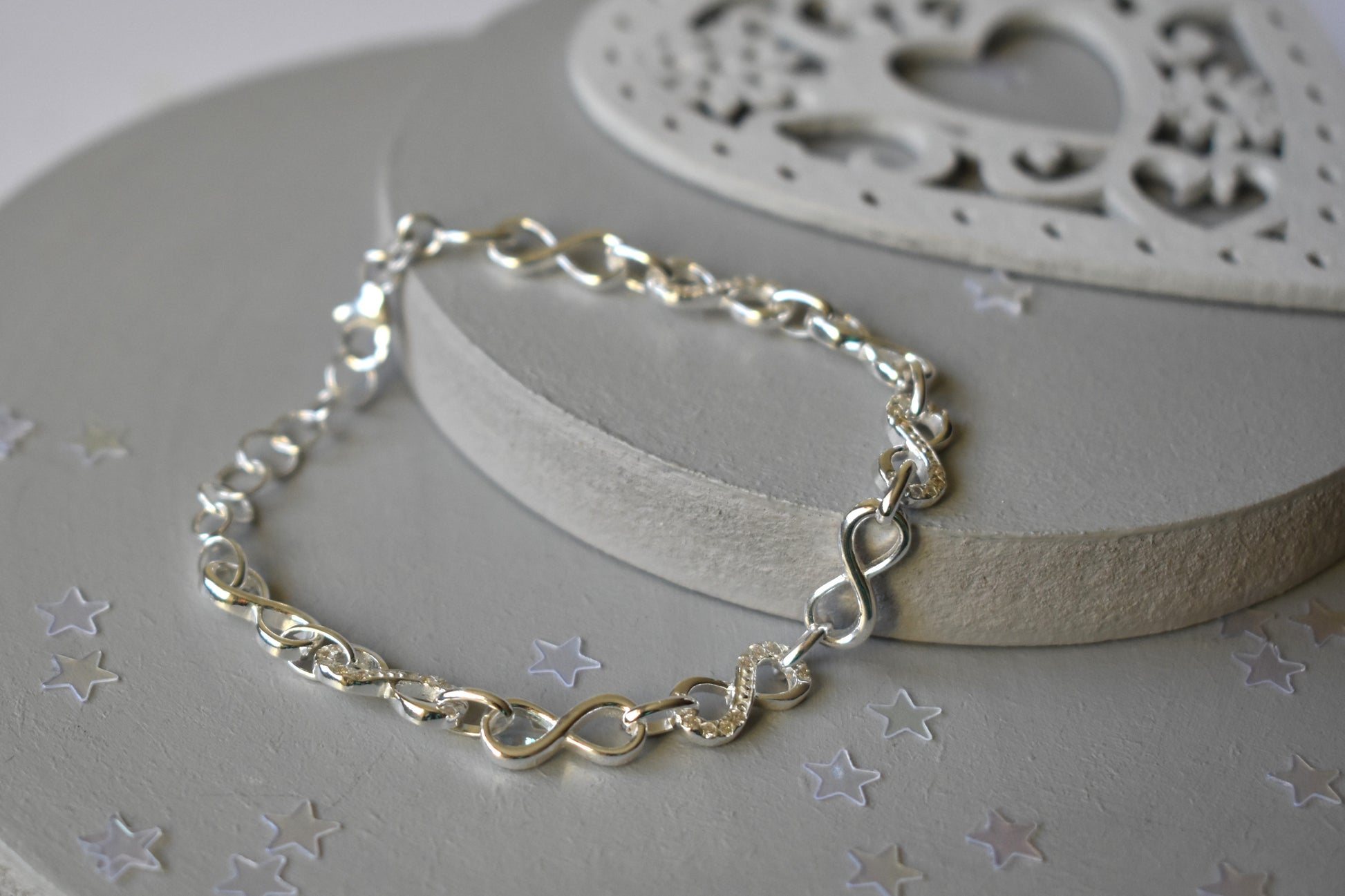 Sterling silver Infinity link bracelet with cubic zirconia inlays. Adjustable.