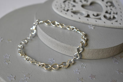 Sterling silver Infinity link bracelet with cubic zirconia inlays. Adjustable.