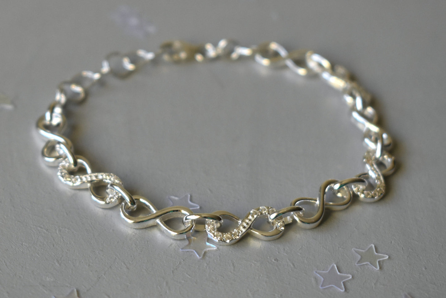 Sterling silver Infinity link bracelet with cubic zirconia inlays. Adjustable.