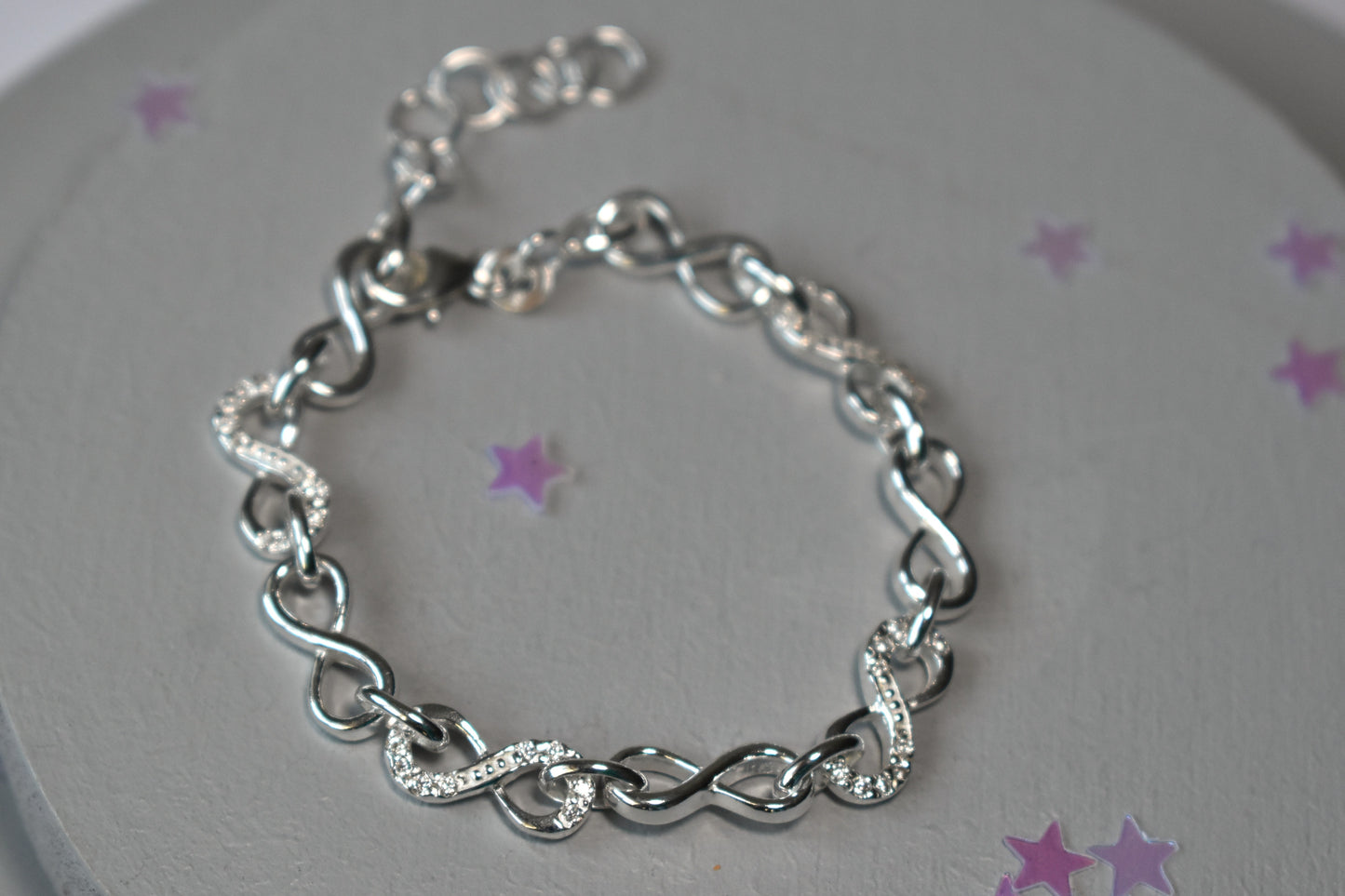 Sterling silver Infinity link bracelet with cubic zirconia inlays. Adjustable.