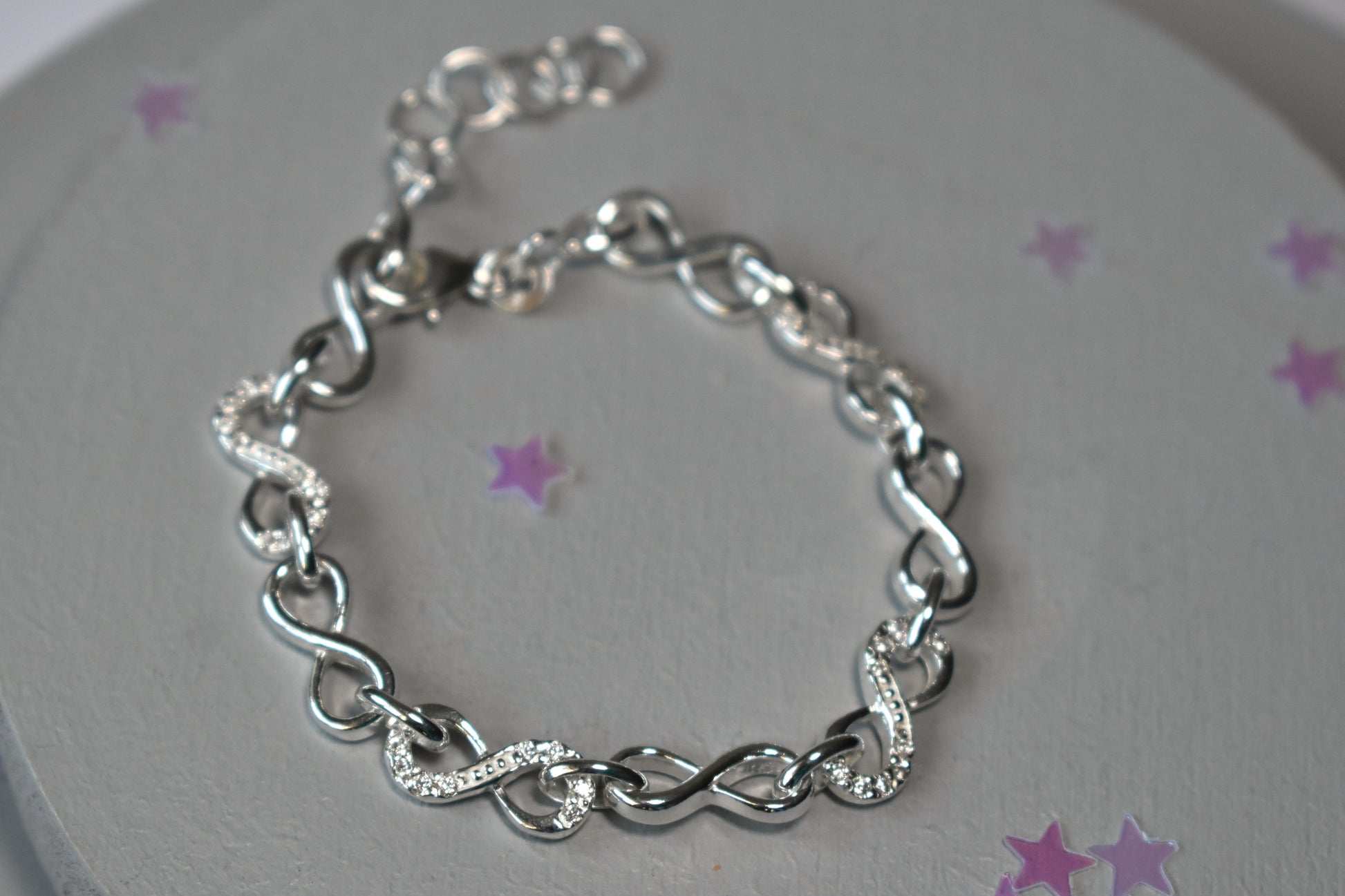 Sterling silver Infinity link bracelet with cubic zirconia inlays. Adjustable.