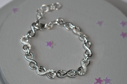 Sterling silver Infinity link bracelet with cubic zirconia inlays. Adjustable.