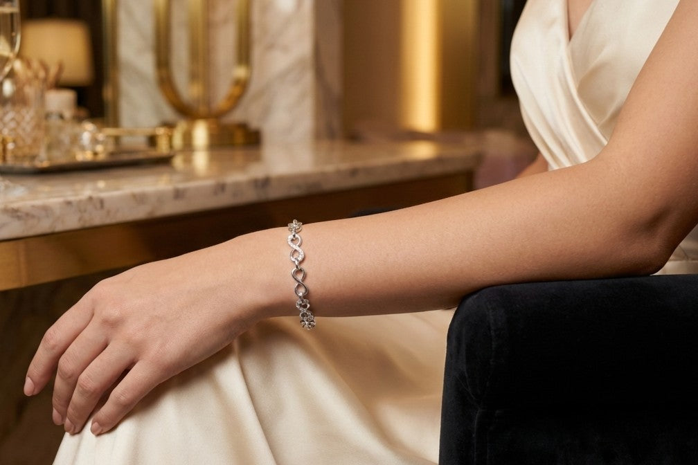 Model wears Sterling silver Infinity link bracelet with cubic zirconia inlays. Adjustable.