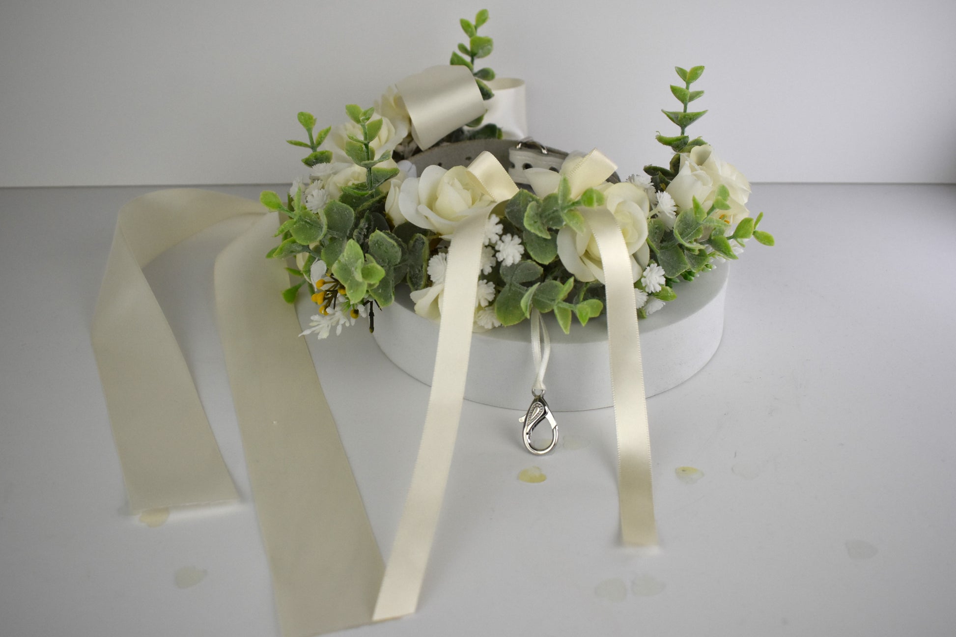 Ivory Silk Dog Ring Bearer Collar. Featuring delicate ivory silk roses and buds with a touch of woodland frosted greenery, this collar is finished with your choice of satin ribbon to match your colour scheme. Optional ring bearer clasp