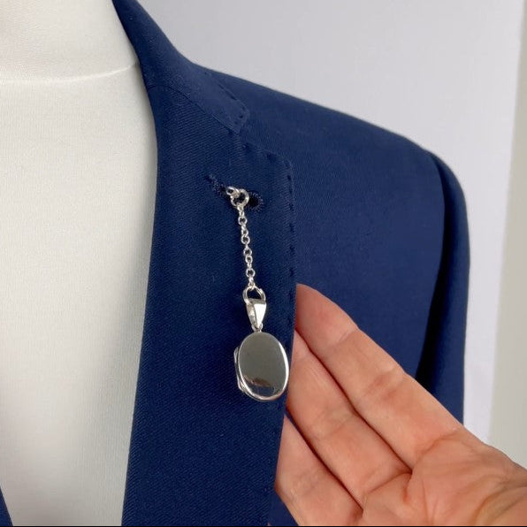 Sterling silver oval photo pocket locket shown with t bar fastening through buttonhole