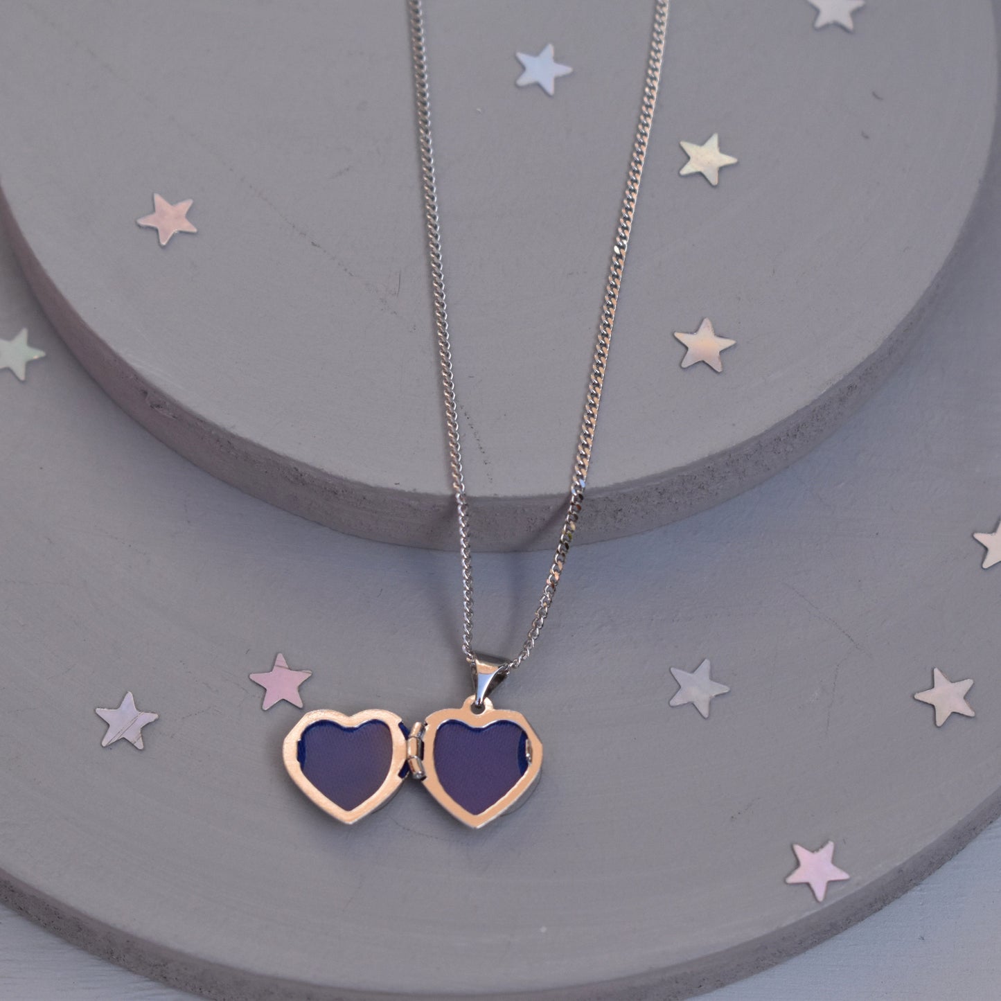 Heart-shaped paw print opening photo locket on sterling silver chain shown open  with photo apertures