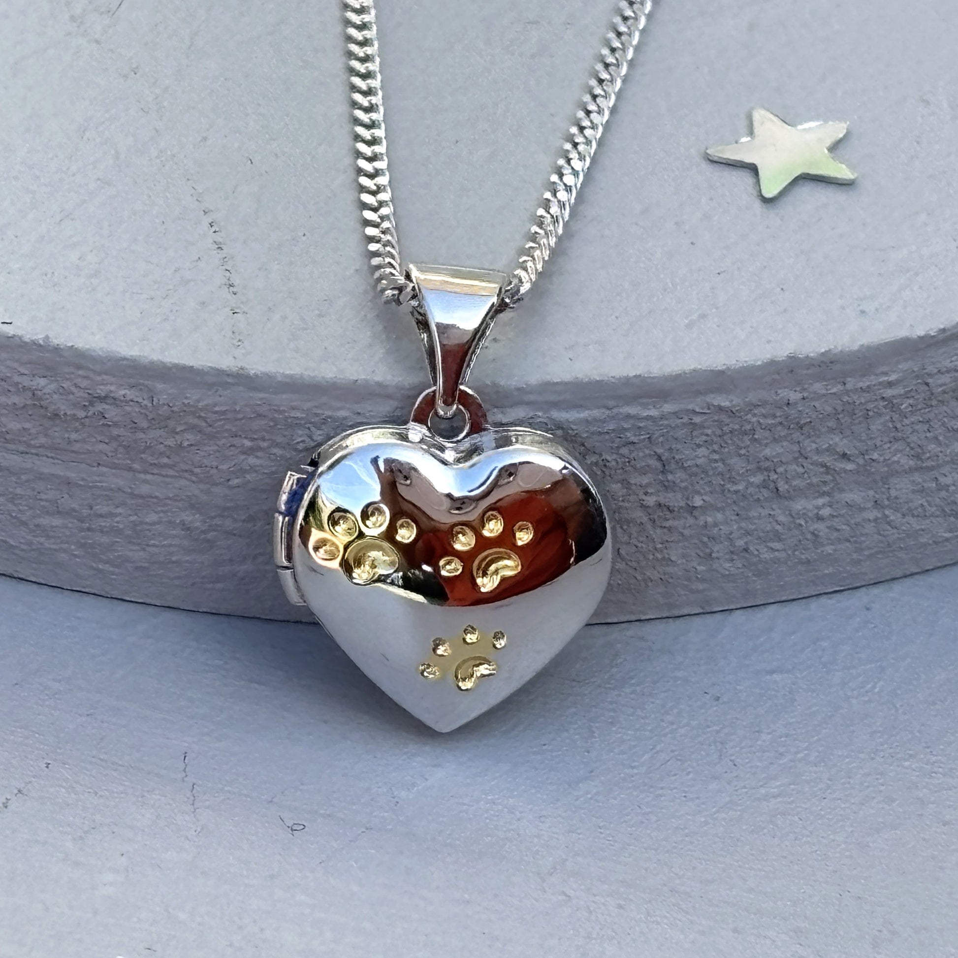 Close up of Heart-shaped paw print opening photo locket on sterling silver chain