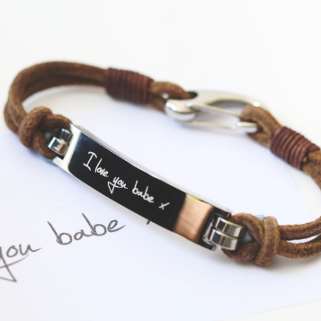 A brown leather bracelet with a central metal plate engraved with your own words and a silver lobster clasp
