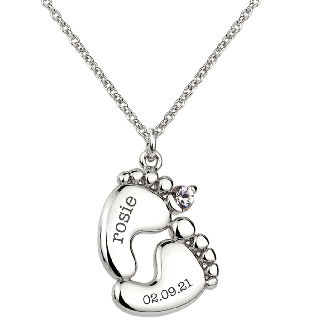 Personalised baby feet necklace. Engraved with baby’s name and date of birth on adjustable necklace. Shown in silver plate.
