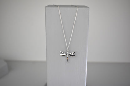 Dragonfly is sterling silver with a sparkling cubic zirconia crystal on its wing. Hangs on a 16 to 18 inch adjustable sterling silver chain.