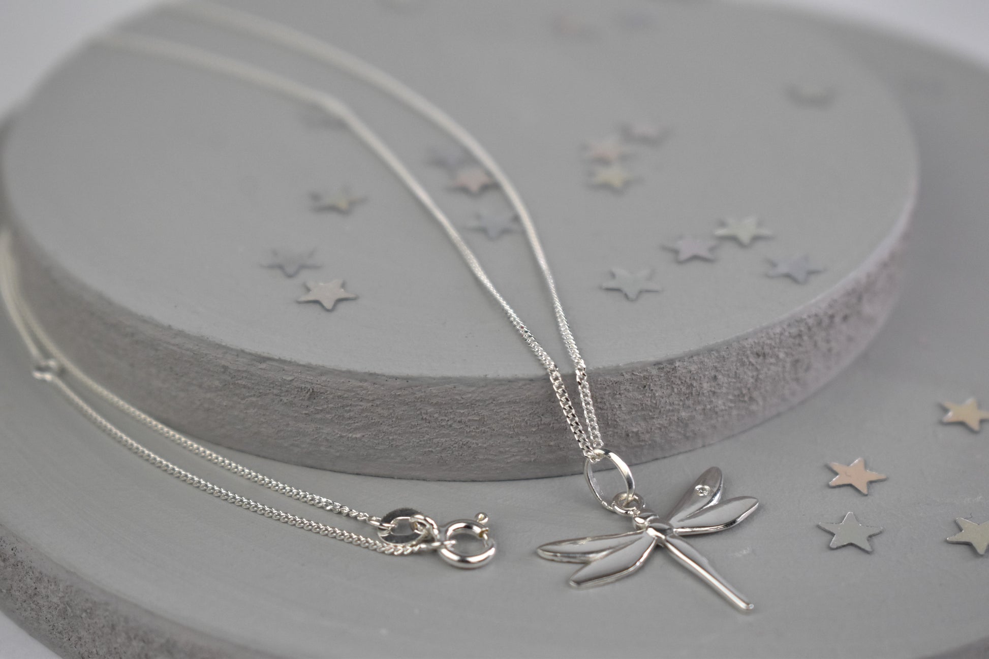 Dragonfly is sterling silver with a sparkling cubic zirconia crystal on its wing. Hangs on a 16 to 18 inch adjustable sterling silver chain.