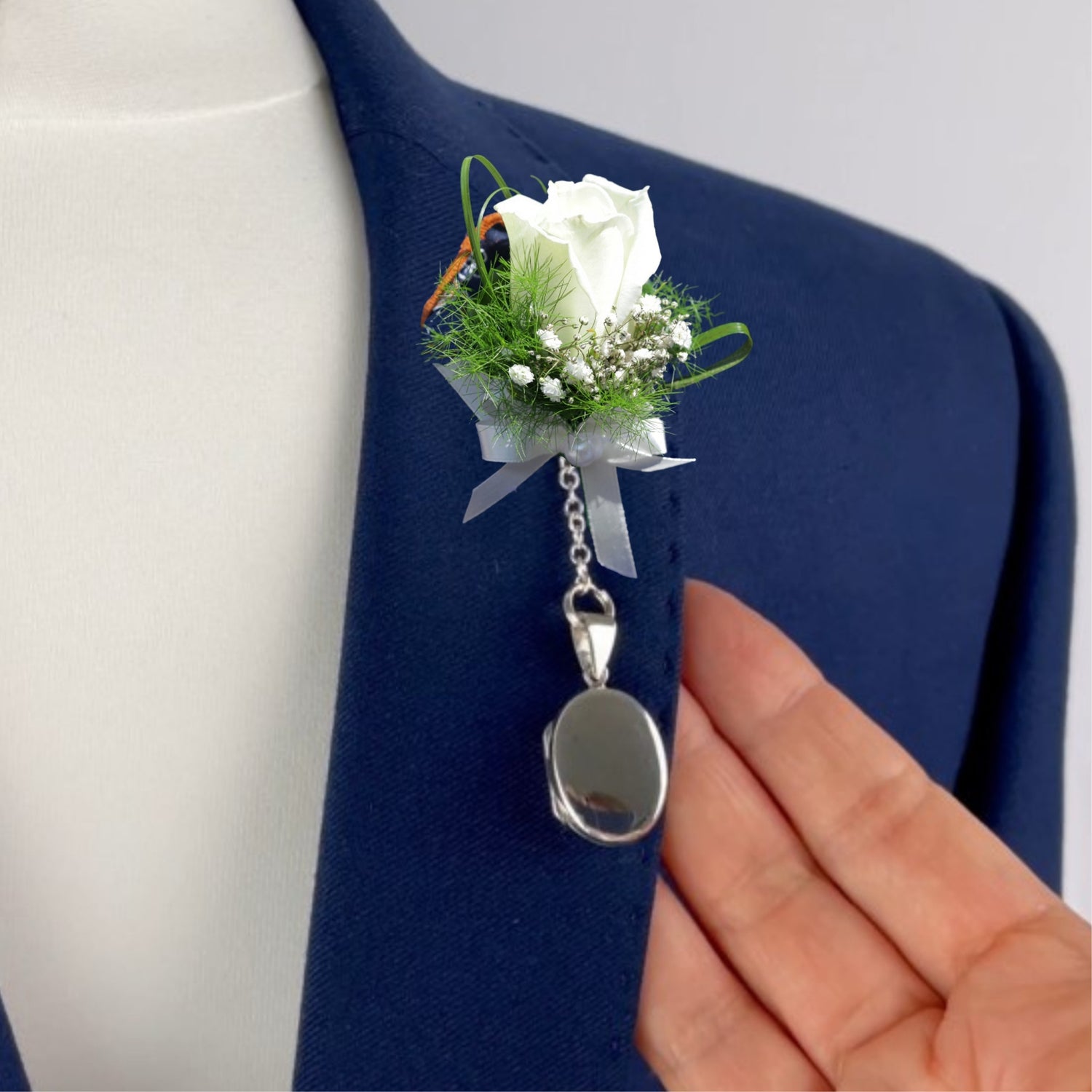 Sterling silver oval photo pocket locket shown attached to boutonniere