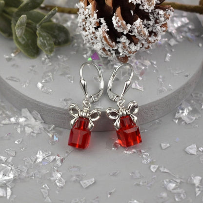A pair of red Austrian Crystal Christmas parcel earrings topped with a bow and fastened onto sterling silver leverback wires.