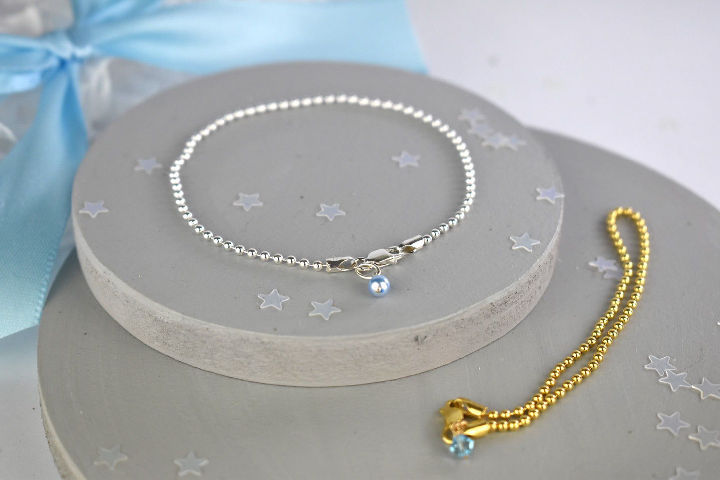 Something Blue Ball Bracelet shown in sterling silver and sterling silver with 14K gold plate finishes. The sterling silver bracelet  has the blue pearl and the gold finish has the blue crystal.