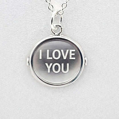 Simulated view of sterlnng silver pendant with markings on both sides that, when spun, form the words "I LOVE YOU"