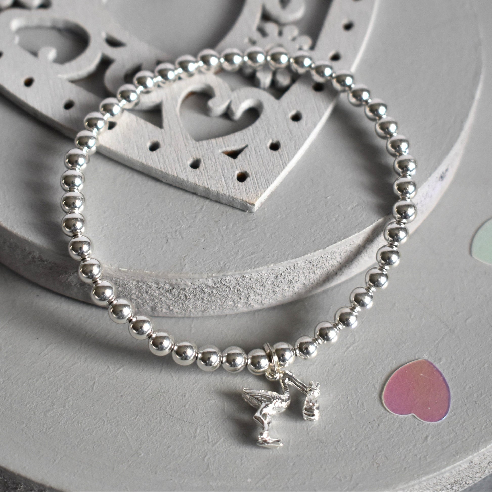 4mm sterling silver beads are threaded onto strong elastic from which is suspended a sterling silver stork carrying a little bundle. The perfect bracelet for new mums.