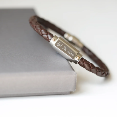 A brown twisted leather bracelet with a stainless steel central plate with your engraving