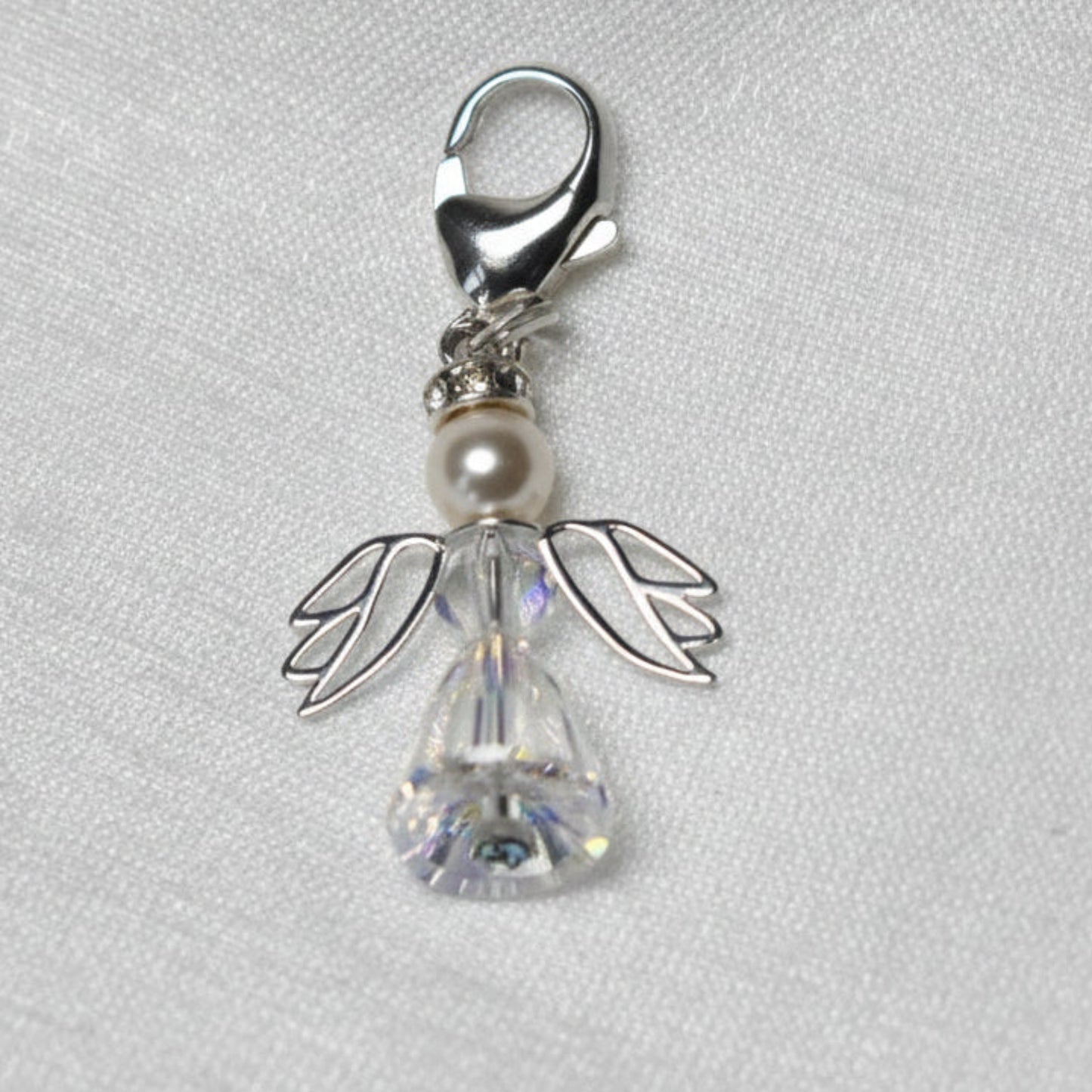 A crystal and pearl angel attached to a strong sterling silver caribiner