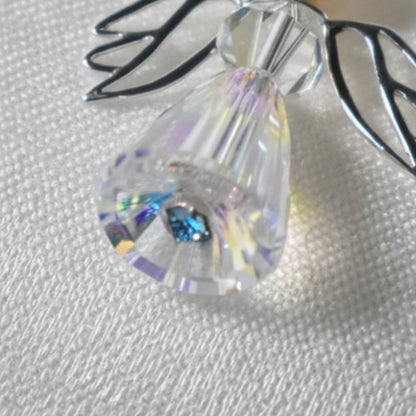 Detail showing the blue pin nestled at the base of the crystal angel charm