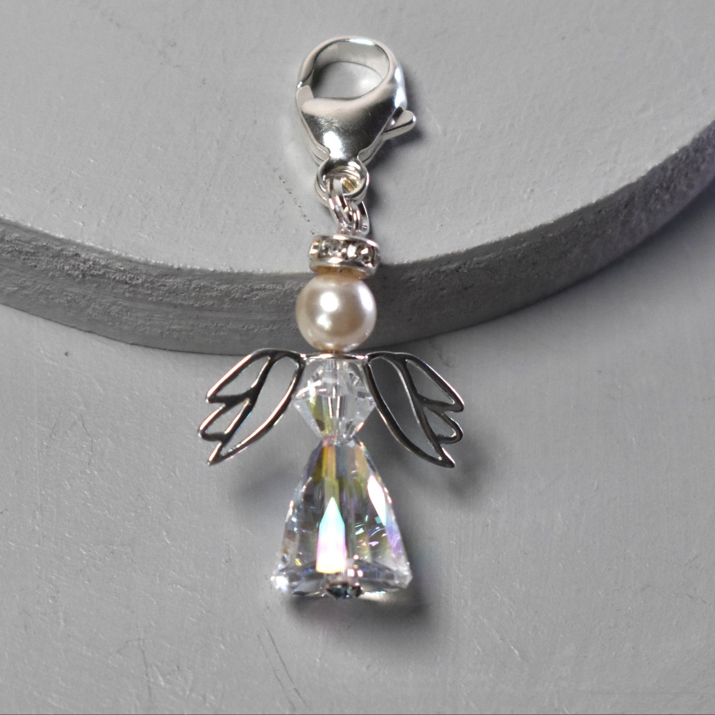 A crystal and pearl angel attached to a strong sterling silver caribiner