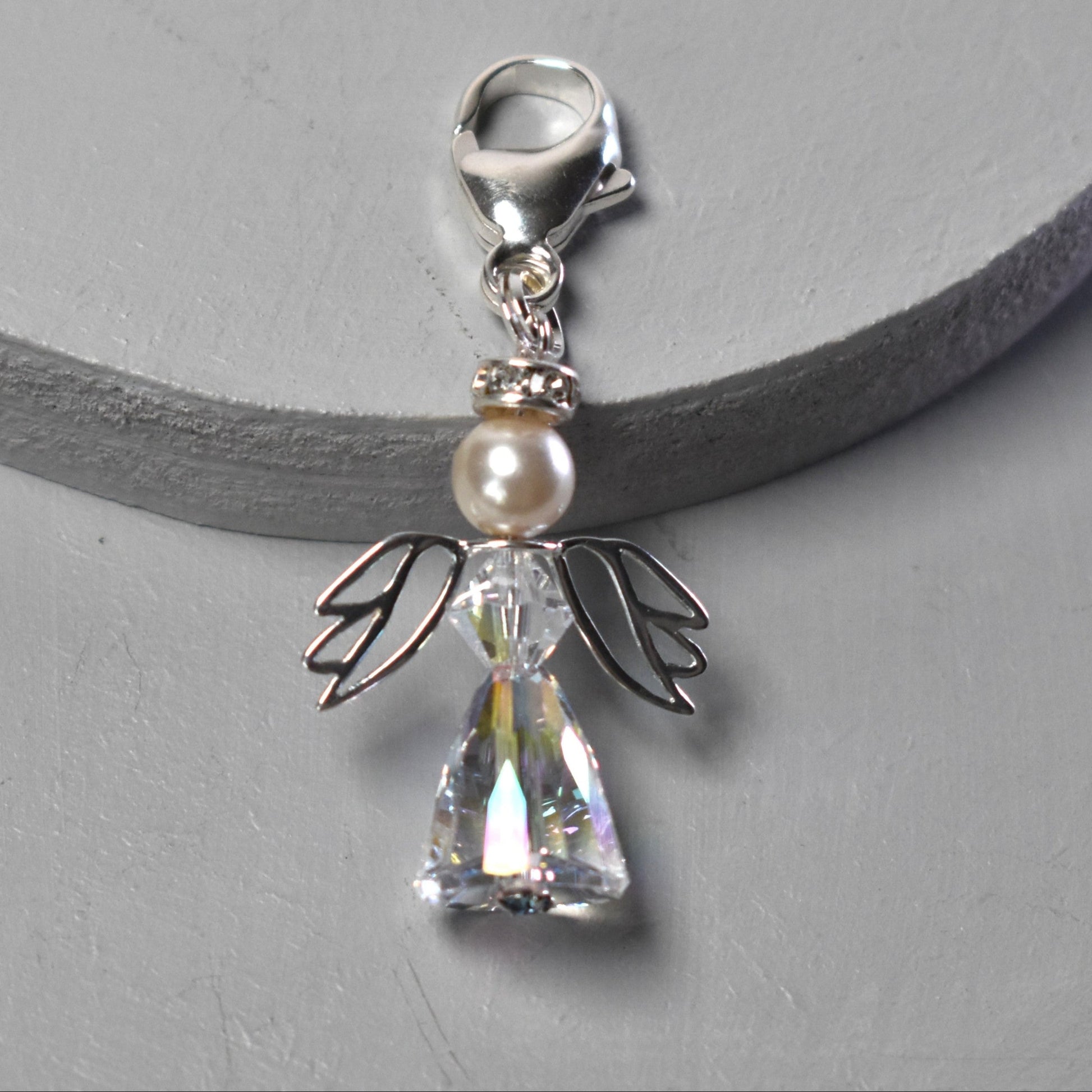 A crystal and pearl angel attached to a strong sterling silver caribiner
