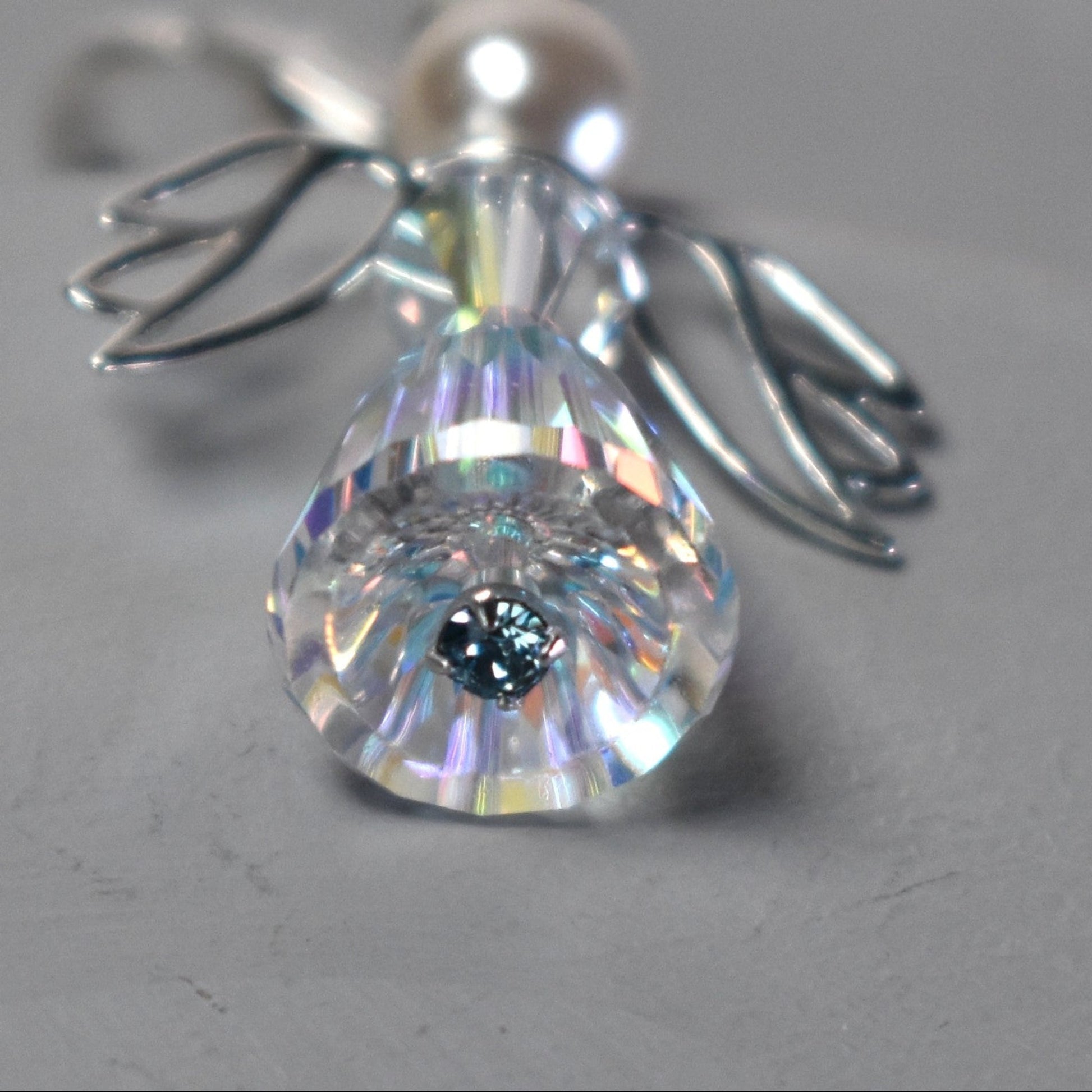 Close up of the angel charm showing the  blue crystal at the base