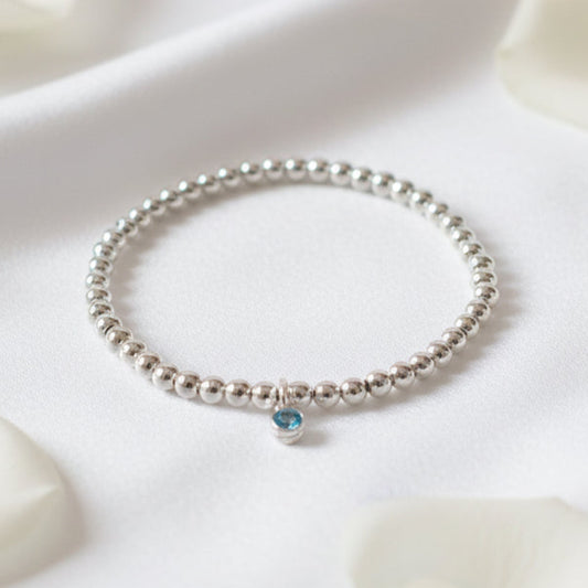 4mm sterling silver beaded bracelet threaded onto strong elastic with 10mm sterling silver birthstone charm (aquamarine)